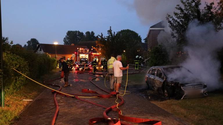 Mensen proberen bij de woning- en autobrand in Genderen te redden wat er te redden valt (foto: FPMB/Erik Haverhals).