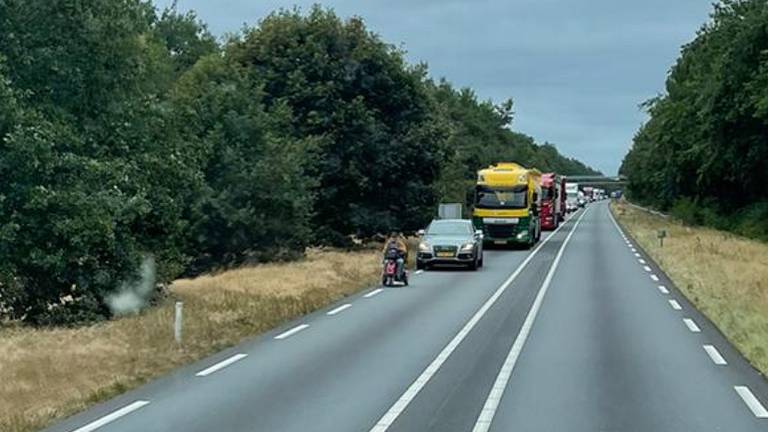 Man rijdt in scootmobiel op N279 met achter hem een file van een kilometer