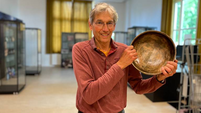Henk Geurts houdt een replica van de bronsschat vast (foto: Jos Verkuijlen)