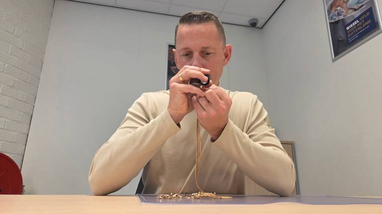 Pjotr Hoogendoorn bekijkt een gouden ketting (foto: Noël van Hooft).