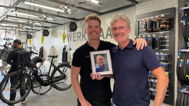 Tommy en Rick in de fietsenwinkel met een foto van opa/ vader Jan (foto: Megan Hanegraaf).