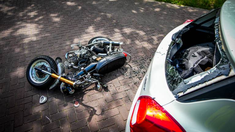 Auto flink beschadigd na ongeluk, motorrijder botst op achterruit