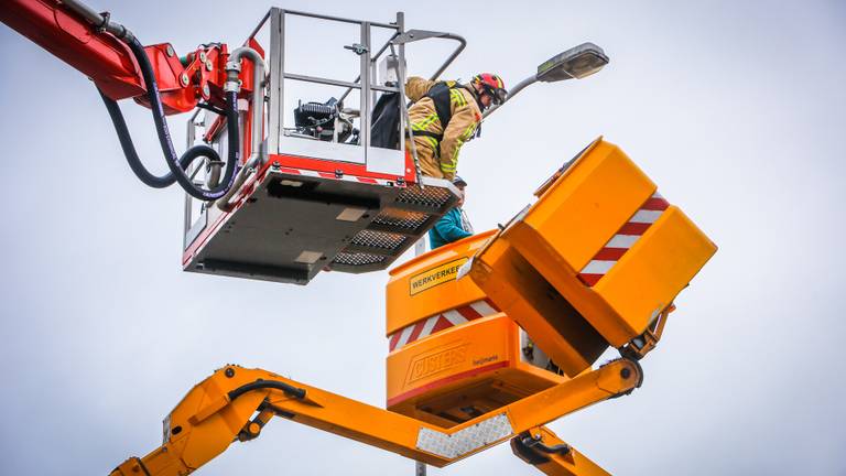 Brandweer haalt man uit bakje van gekantelde hoogwerker