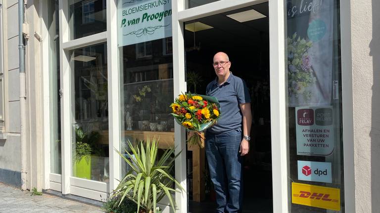Martijn Michielse in de deuropening van zijn bloemenzaak (foto: Jan Peels)