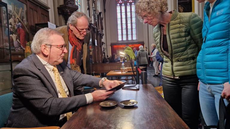 Het taxeren van de tinnen schotels in de St. Petruskerk (foto: Omroep Brabant).