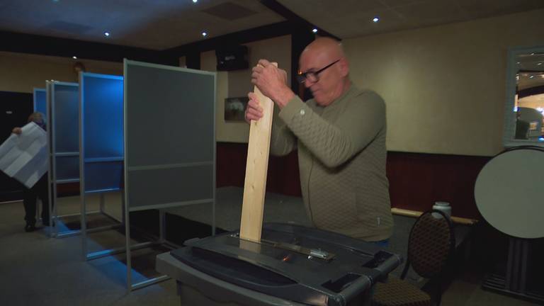 Met een lange plank stamt Rene de stembiljetten aan (beeld: Omroep Brabant).