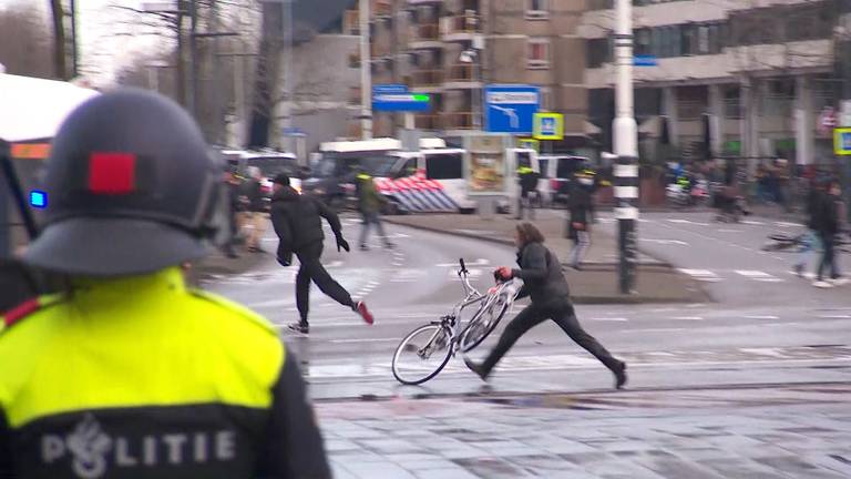 Man gooit fiets onder waterkanon (foto: archief). 