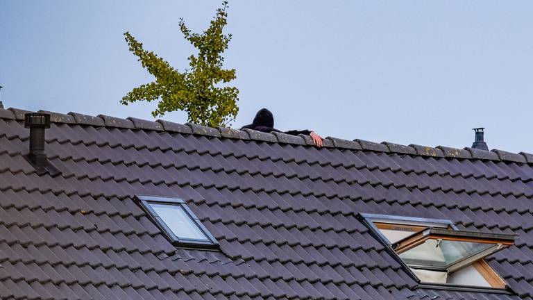 Het is niet duidelijk waarom de man het dak op is geklommen (foto: Jack Brekelmans/SQ Vision).