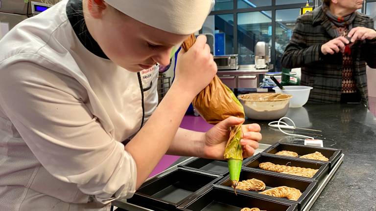 Patisserie-student Medde spuit heel geconcentreerd een van de duizenden chocoladeletters (foto: Jan Peels) 