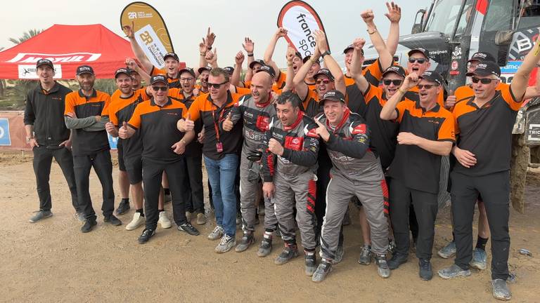 Janus van Kasteren (eerste rij, derde van rechts) viert de zege in de Dakar Rally met zijn team (foto: Ronald Sträter)