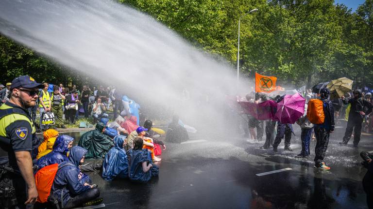 De politie zette een waterkanon in tegen activisten van Extinction Rebellion die de A12 in Den Haag voor de zevende keer blokkeerden. (foto: ANP 2023/Phil Nijhuis).