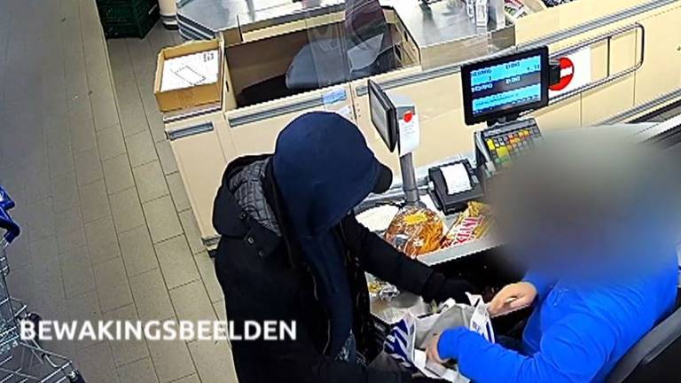 ALDI-medewerker vult de plastic tas met geld en sigaretten (foto: politie).