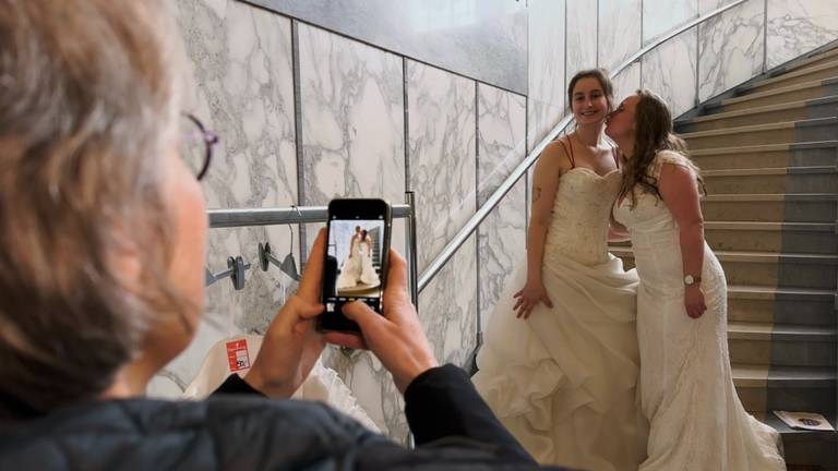 Twee vriendinnen hebben grootste lol in hun tweedehands trouwjurken (foto: Jan Peels) 