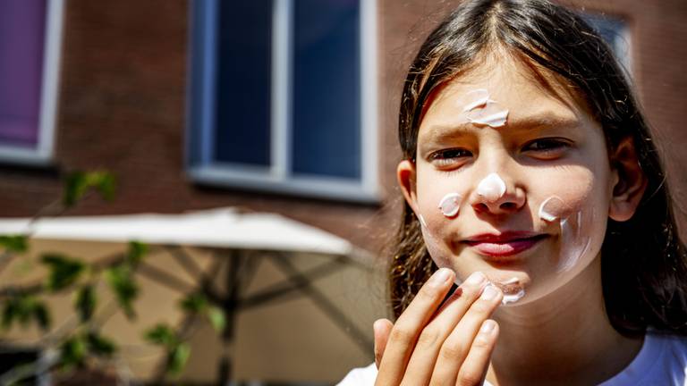 Een meisje smeert zich in met zonnebrandcrème (Foto: ANP). 