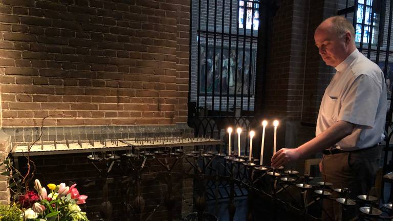 Pastoor John van de Laar steekt een kaarsje aan in de kerk in Uden (Foto: Imke van de Laar)