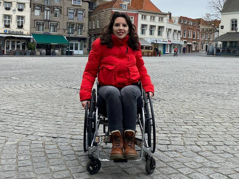 Christel Verbogt in haar rolstoel op de Grote Markt in Bergen op Zoom.