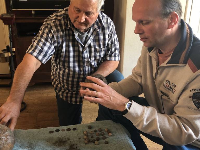 Theo Valentijn (l) en Ronald van Genabeek bekijken de vondsten