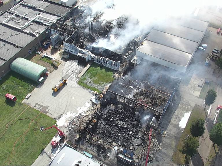 De door brand verwoeste bedrijven op industrieterrein Kraaiven in Tilburg. (Dronebeeld BrandweerMWB)