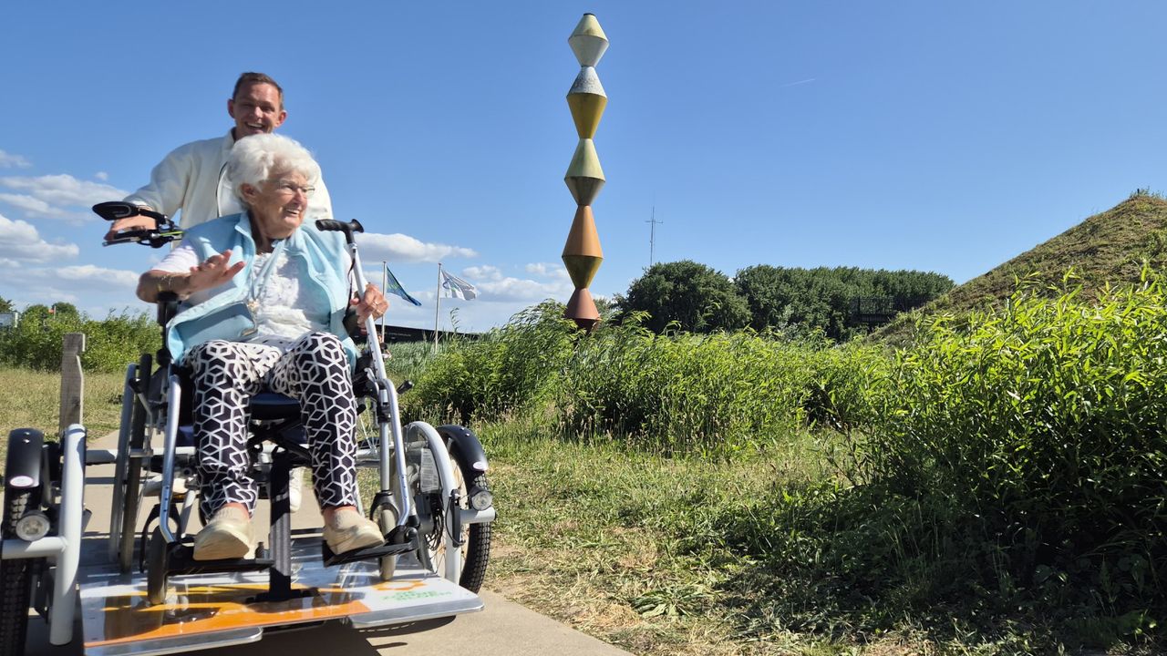 De 84-jarige Sjanie Versluis-Ruijtenberg wordt rondgereden op de rolstoelfiets van De Zonnebloem, bij het Biesbosch MuseumEiland in Werkendam (foto: Niek de Bruijn)
