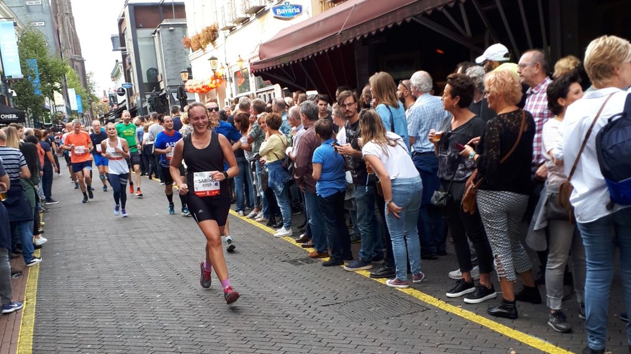 Sabine rent over Stratumseind terwijl familie haar aanmoedigt.