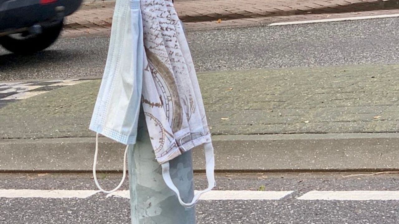 Op sommige plekken worden de mondkapjes zelfs opgehangen bij een verkeersbord.