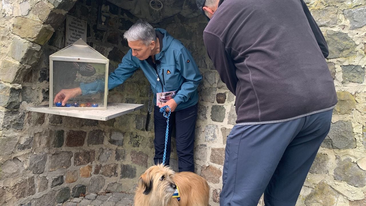 Helma steekt een kaarsje aan in een kapelletje (foto: Carlijn Kösters).