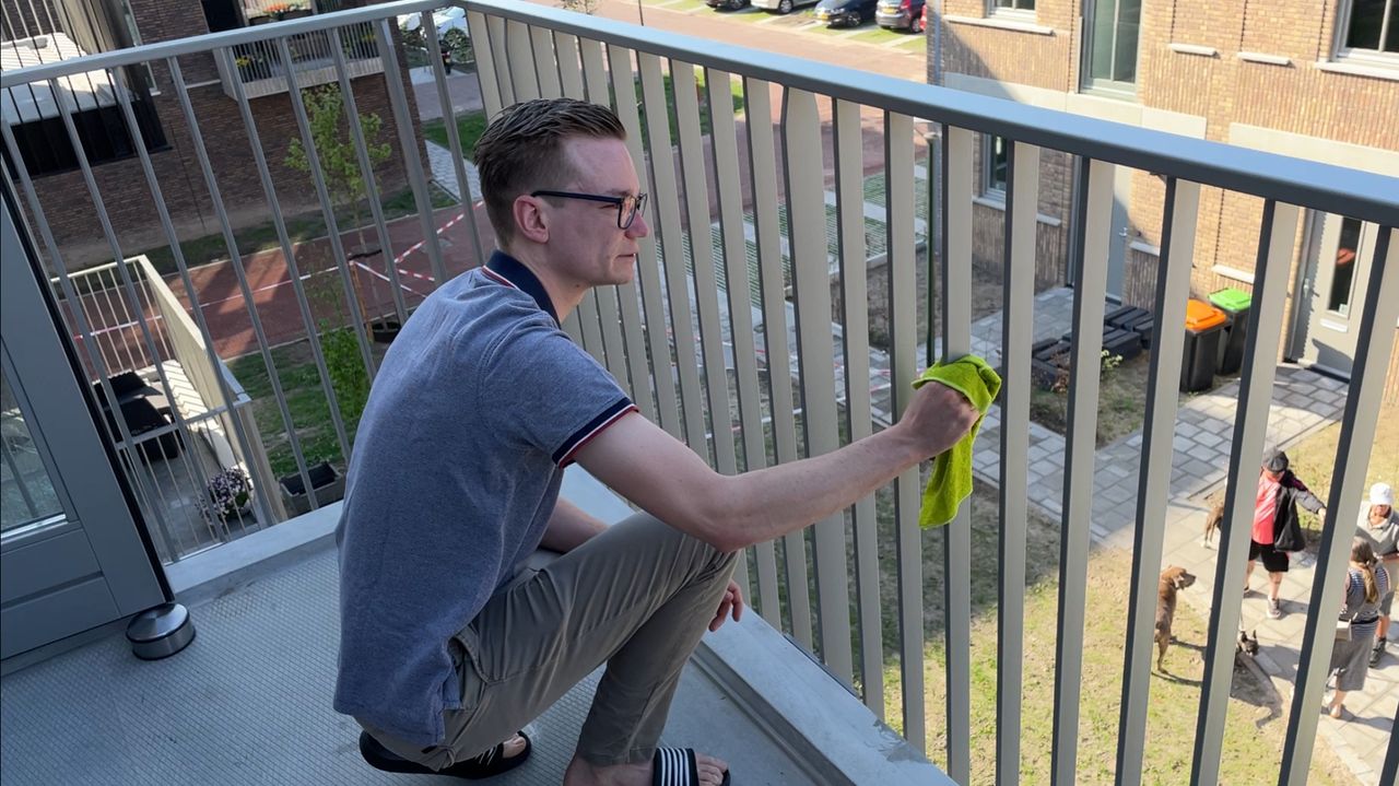 Dennis maakt zijn balkon schoon (foto: Rochelle Moes).