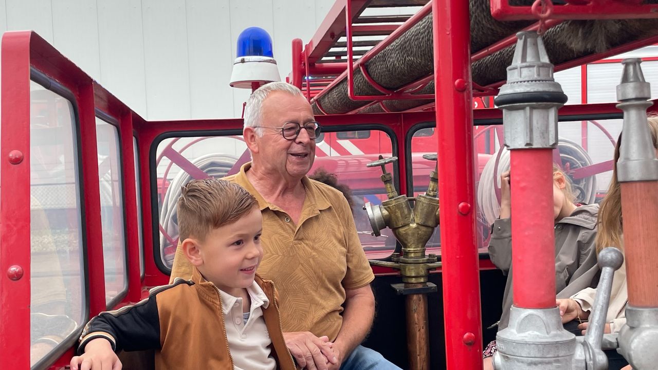 Harrie zit achterop een brandweerwagen (foto: Jos Verkuijlen).