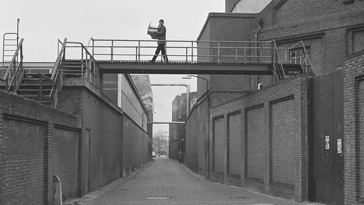 Na de fusie tussen de vleesfabrieken wordt er symbolisch een brug over het Concurrentiestraatje geplaatst (foto: Stadsarchief Oss).