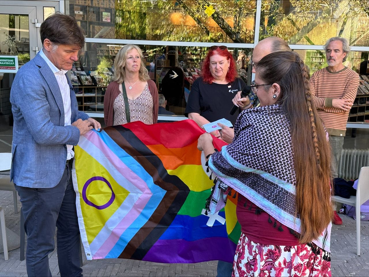 Laura overhandigt de pridevlag aan burgemeester Paul Depla (foto: Omroep Brabant).