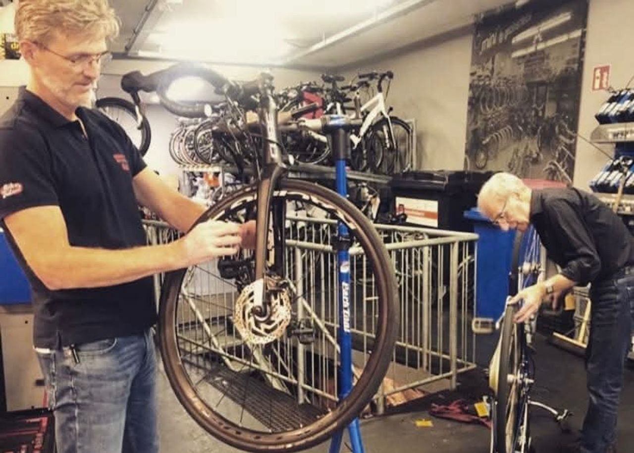 Rick met zijn vader Jan in de werkplaats van hun fietsenwinkel (foto: privé).