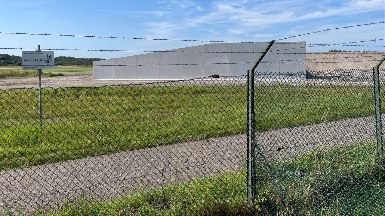 De muur beperkt het zicht op de straaljagers die vertrekken vanaf de vliegbasis (foto: Rene van Hoof).