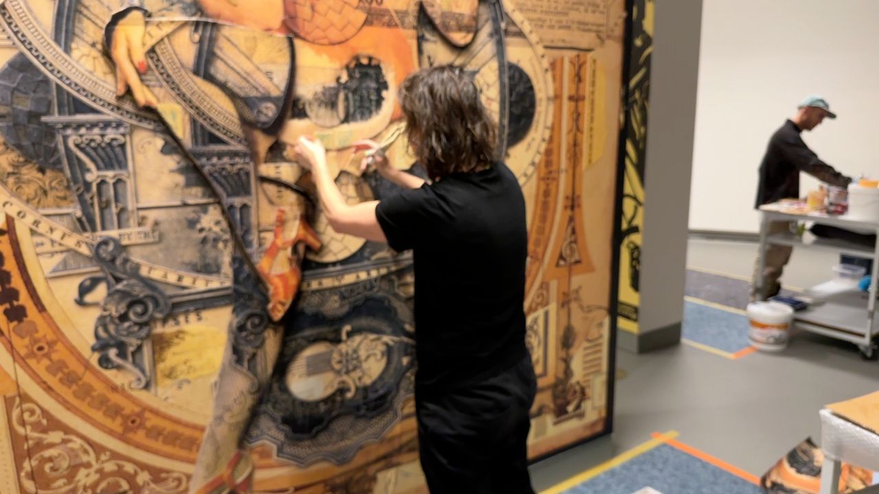 Kunstenares Handiedan werkt met papier en lijm voor haar mural.
