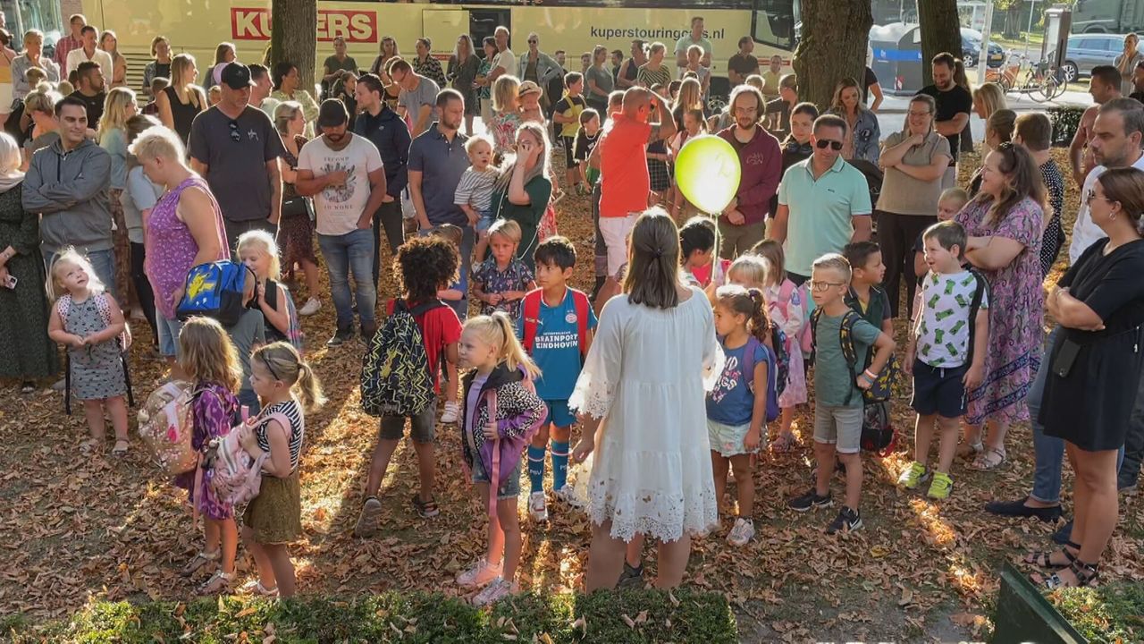 De verschillende groepen verzamelen zich op het schoolplein.