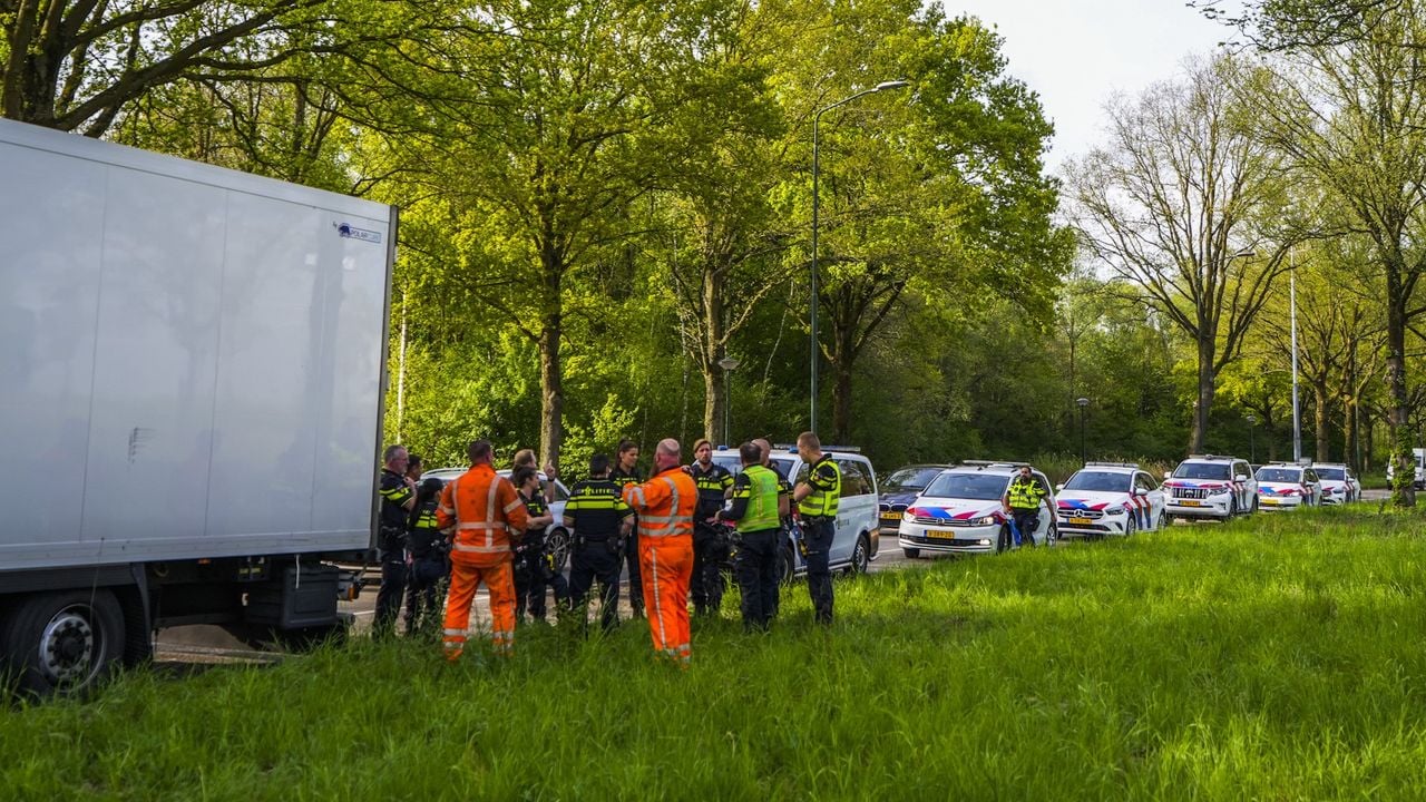 Agenten overleggen met personeel van het bergingsbedrijf, politiewagens staan klaar (foto: SQ Vision).