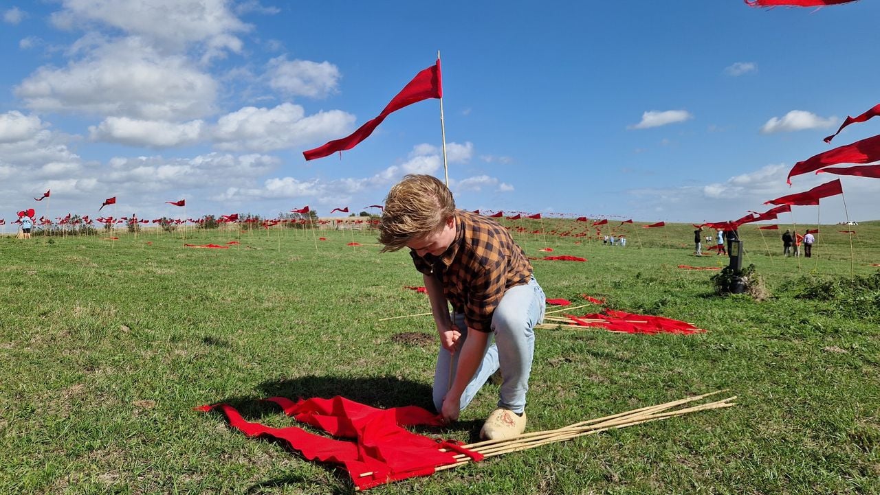 Réan Gerritsen (18) hard aan het werk om de vlaggen de grond in te krijgen (foto: Tom Berkers).