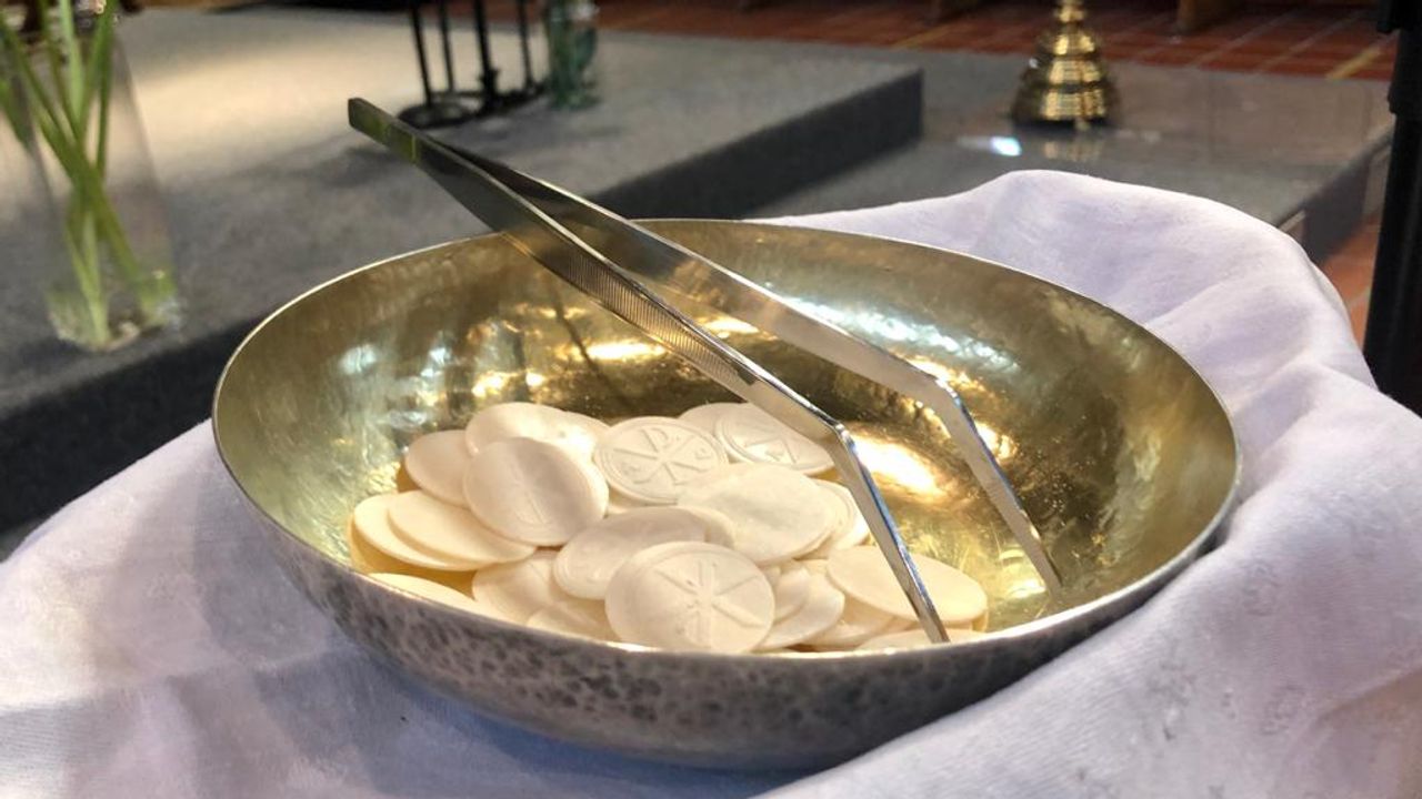 De hosties worden met een pincet uitgereikt (foto: Erik Peeters).