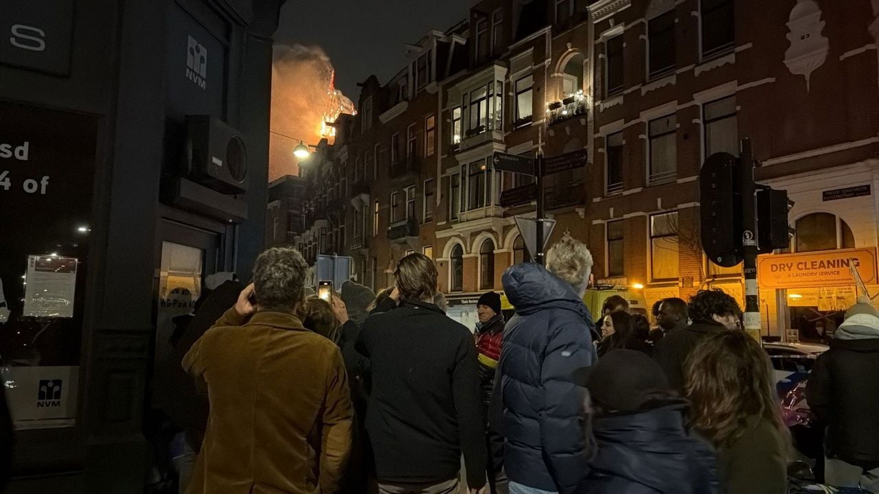 Mensen kijken op straat naar de brand in Amsterdam - NOS
