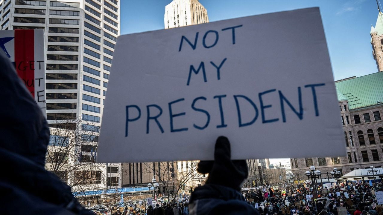 Iemand houdt een bord met de tekst "niet mijn president" omhoog tijdens een groot protest in Minneapolis - AFP