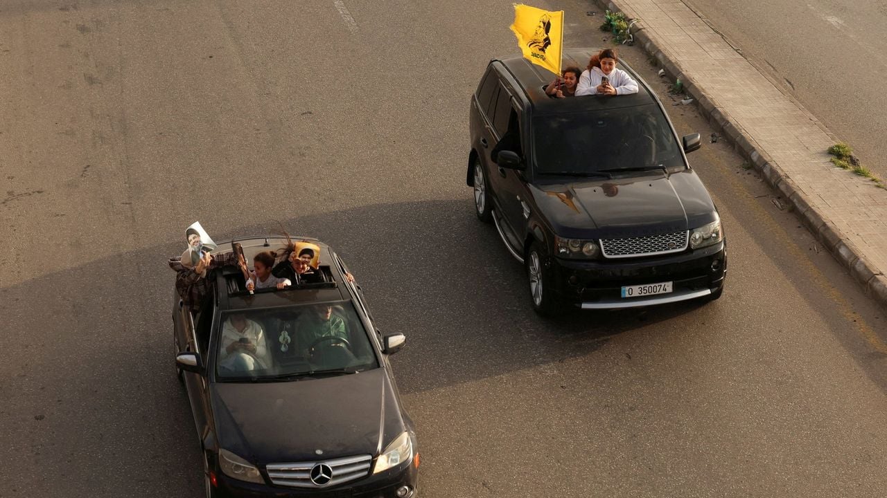Mensen in auto's tonen foto's van voormalig Hezbollah-leiders en vlaggen van de militante beweging - Reuters