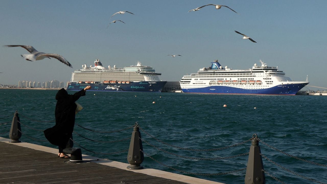 Een vrouw voert meeuwen, met Mein Schiff-cruiseboten voor anker in Doha, beeld van begin deze maand - AFP