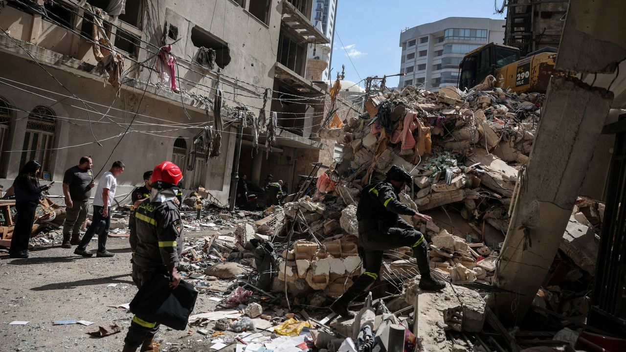 Reddingswerkers op de plek waar een verwoestende Israëlische aanval plaatsvond in Beiroet - Reuters