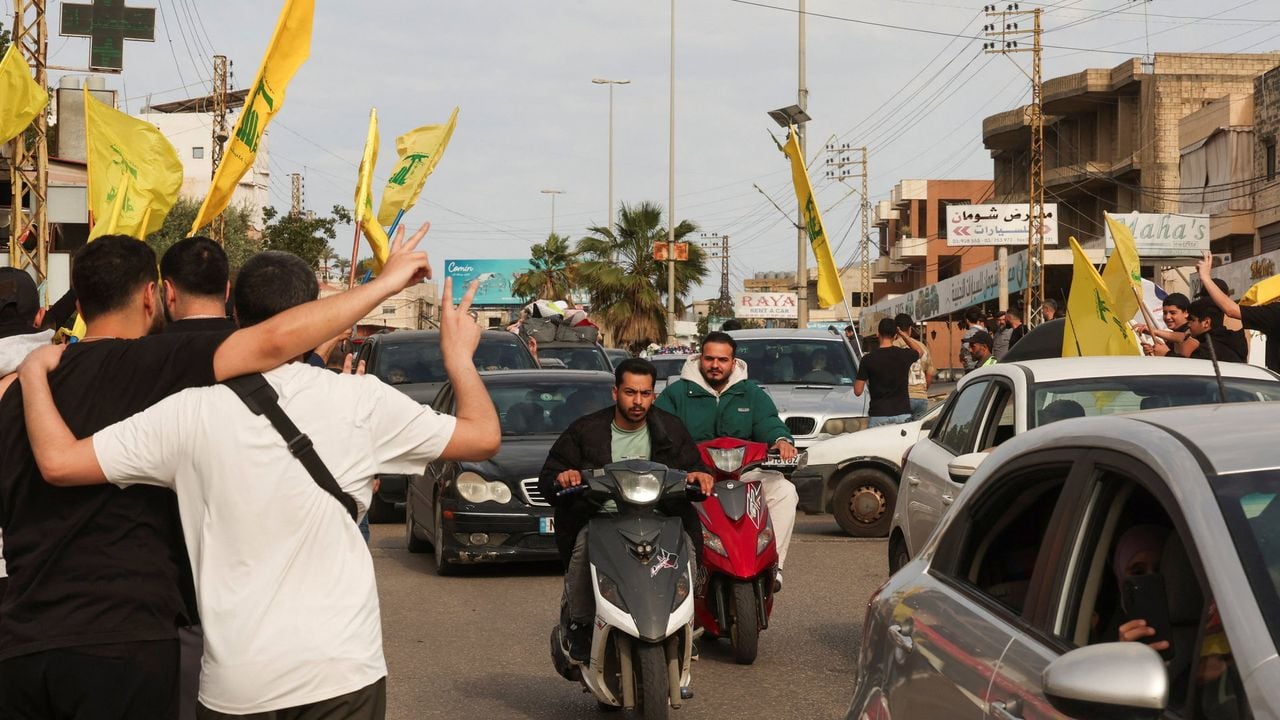 Libanezen vieren het staakt-het-vuren en tonen Hezbollah-vlaggen in de buurt van Nabatieh - Reuters