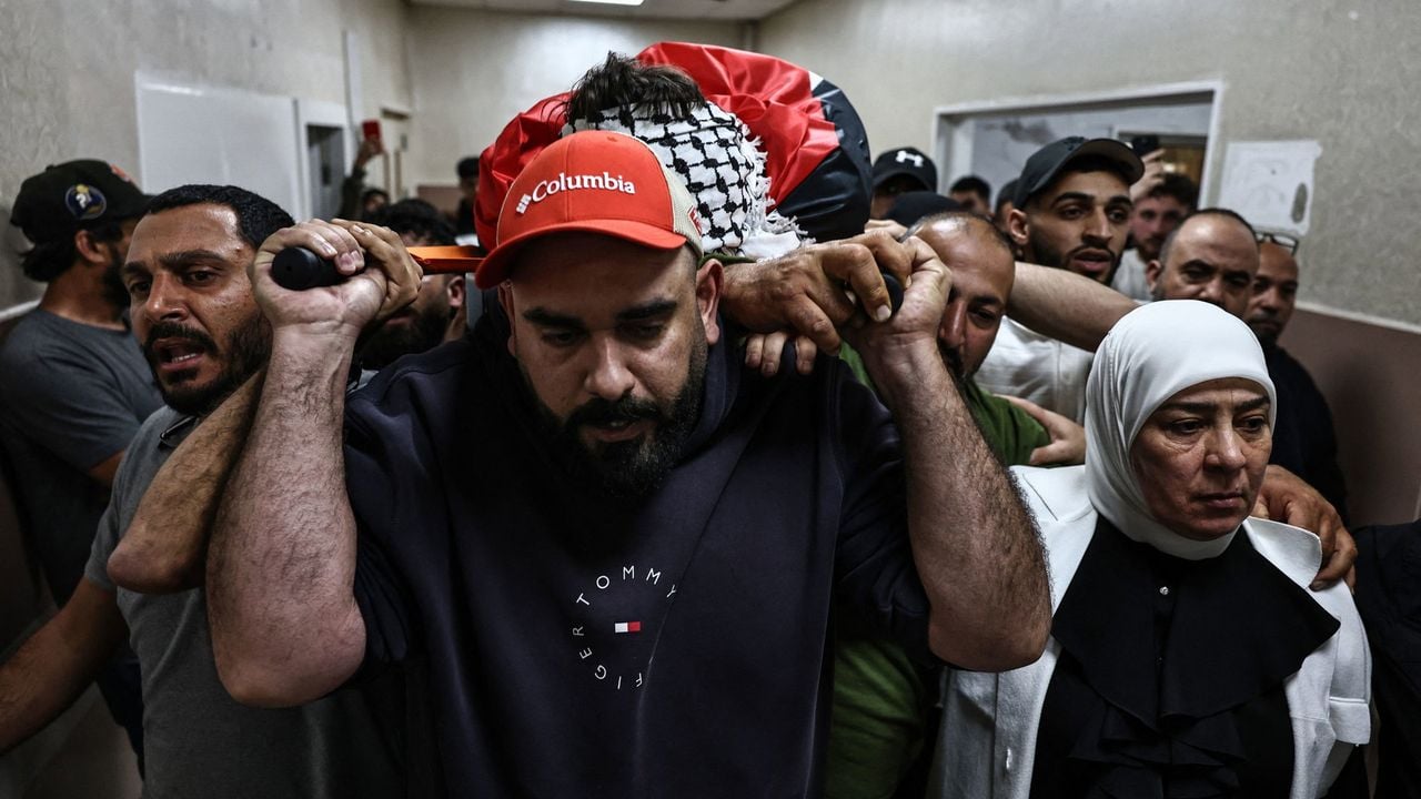 Rouwenden dragen het lichaam van de 29-jarige Palestijnse man die in Deir Dibwan door vermeend kolonistenvuur om het leven kwam - AFP