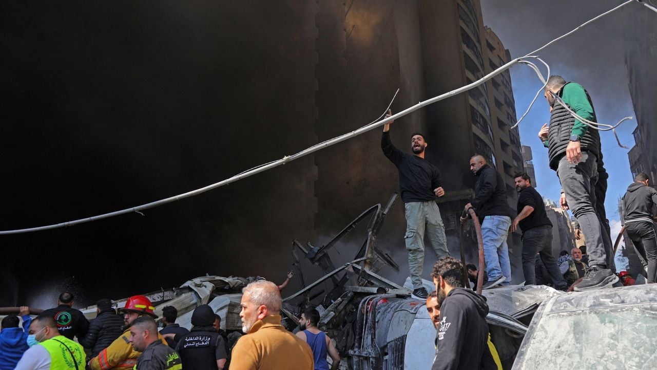 Mensen verzamelen zich op straat in een getroffen wijk in Beiroet - AFP