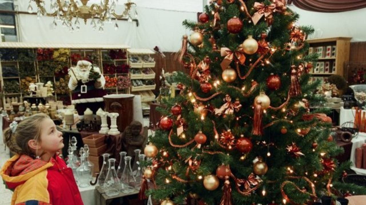 Een meisje kijkt op 10 december 1997 naar een versierde kerstboom in tuincentrum Groenrijk (foto: Stadsarchief Breda). 