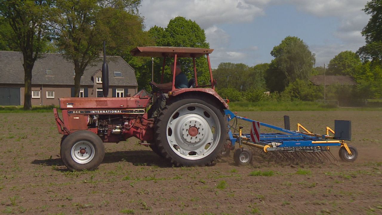 Boer John op zijn trekker met wiedeg.