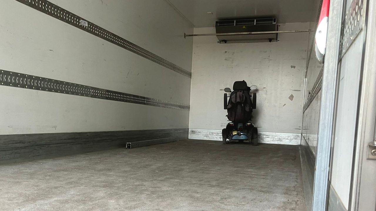 De scootmobiel wordt opgehaald met een vrachtwagen.