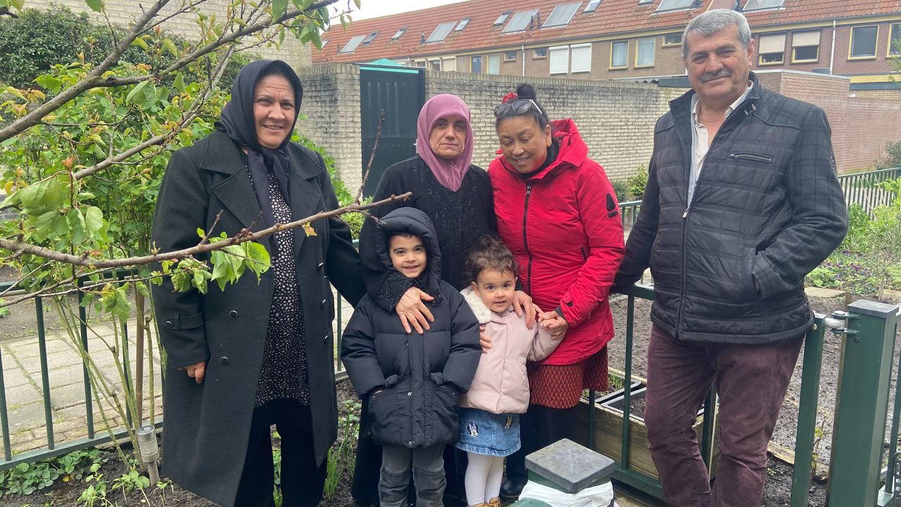 Shirley (in de rode jas) met enkele bewoners van de Textielbuurt in de moestuin (foto: Marleen Kuijsters).