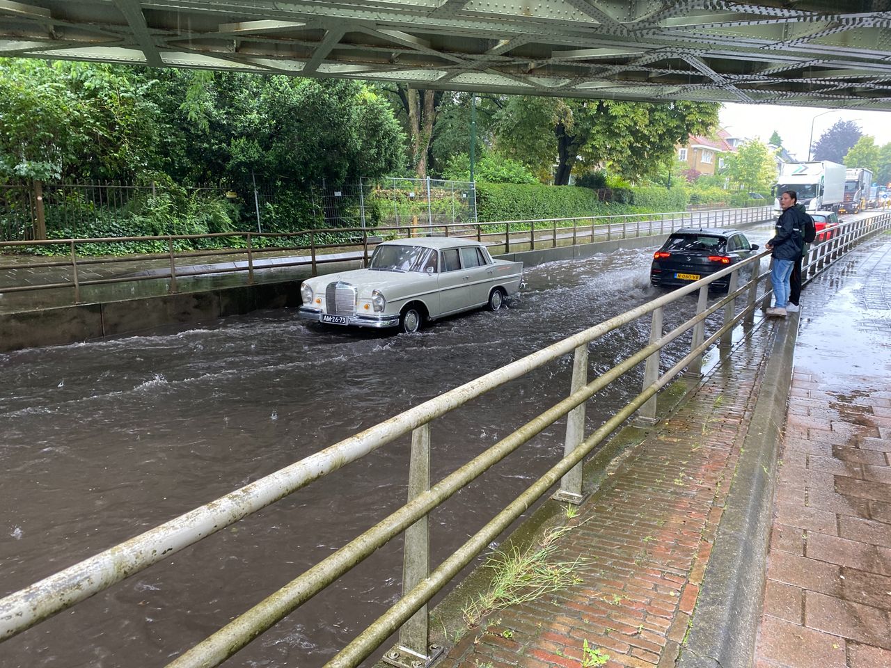 Auto strandt onder viaduct vol water. 